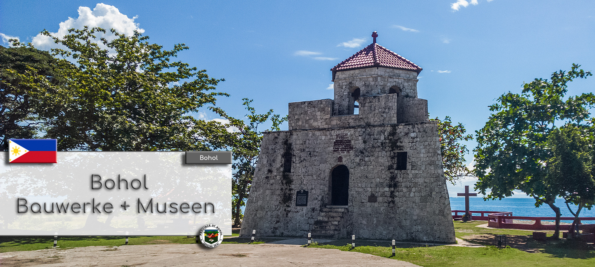 Der Watchtower Punta Cruz auf der Insel Bohol. Im Hintergrund ist das alte Kolzkreuz und das Meer zu sehe. Im Textfeld steht geschrieben: Bohol Bauwerke und Museen. Wappen der Philippinen und der Provinz Bohol.